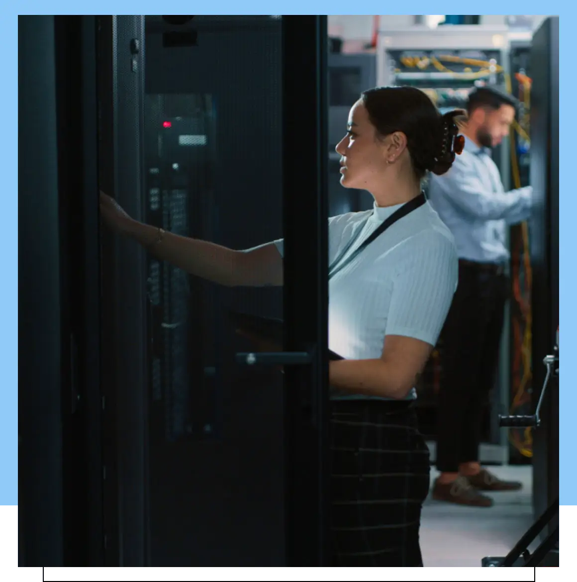 Two people working in a server room.